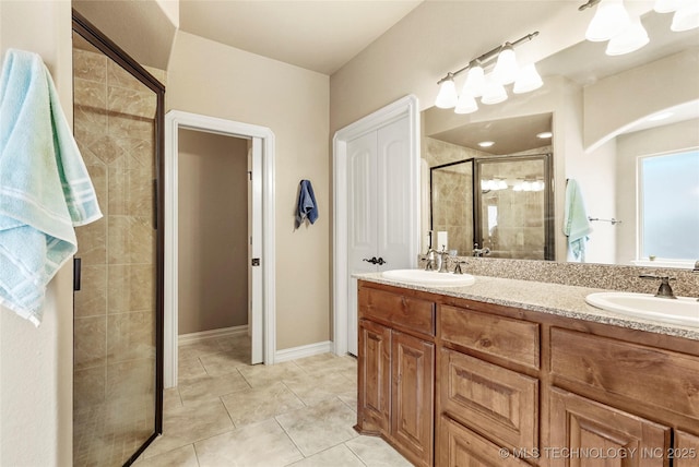 full bathroom featuring tile patterned floors, double vanity, a stall shower, and a sink