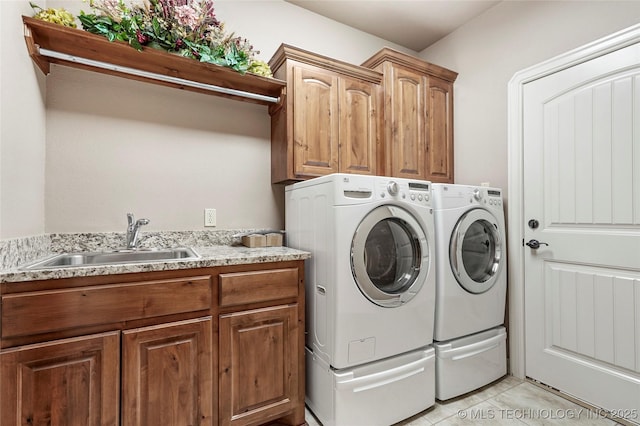 laundry room featuring a sink, cabinet space, washing machine and dryer, and light tile patterned floors