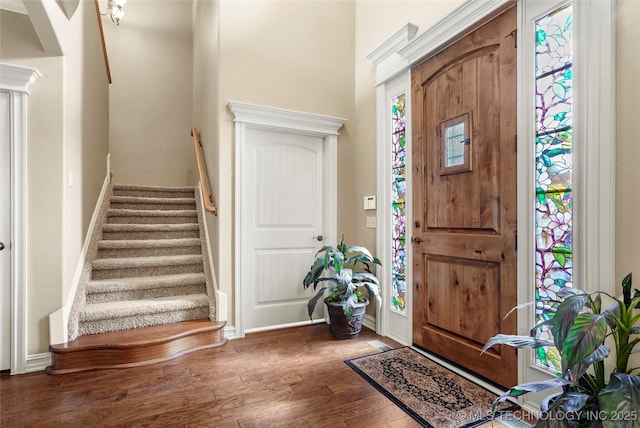 entryway featuring stairway, wood finished floors, and baseboards