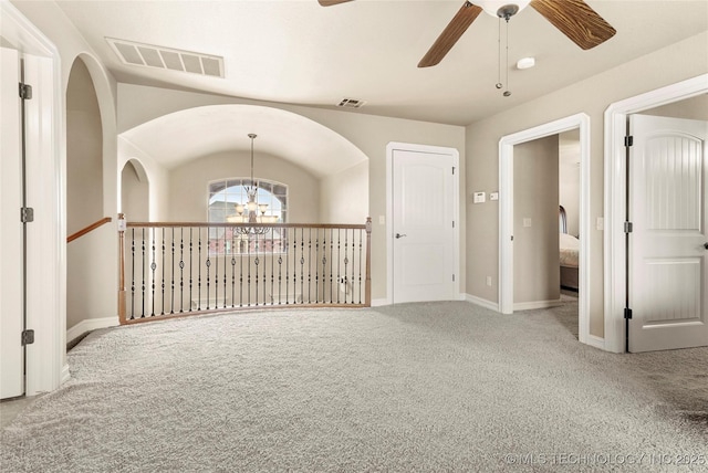 empty room featuring visible vents, baseboards, carpet flooring, and ceiling fan with notable chandelier