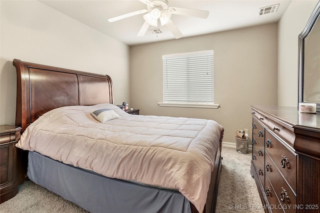 bedroom with visible vents, light colored carpet, baseboards, and ceiling fan