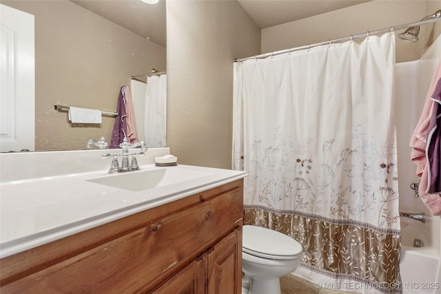 full bathroom with toilet, vanity, and a textured wall