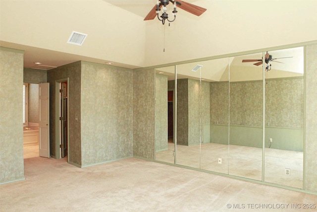 unfurnished bedroom with a closet, visible vents, carpet flooring, and a high ceiling