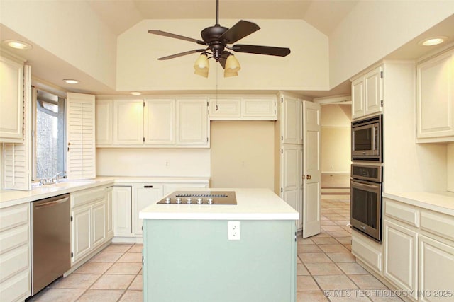 kitchen featuring light tile patterned flooring, a sink, light countertops, appliances with stainless steel finishes, and a center island