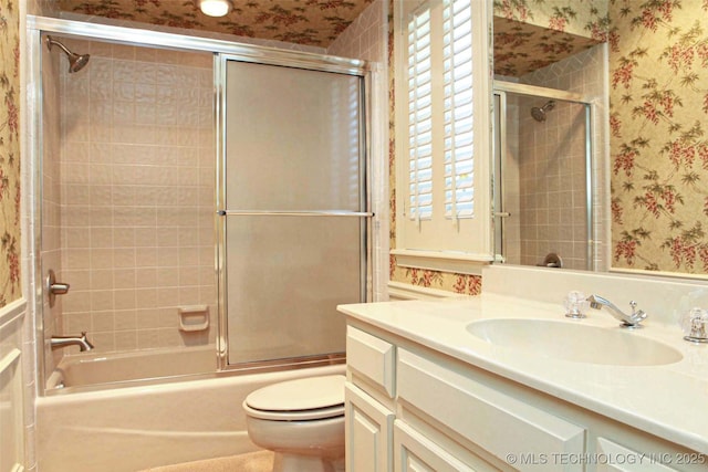 bathroom with enclosed tub / shower combo, toilet, wallpapered walls, and vanity