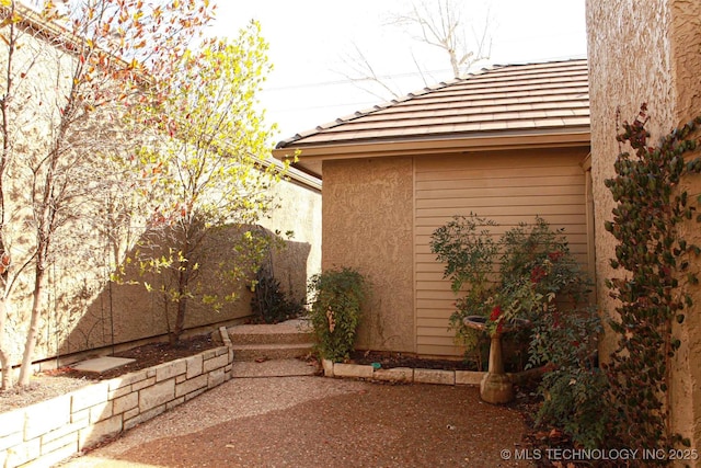 view of side of property featuring stucco siding and a patio area