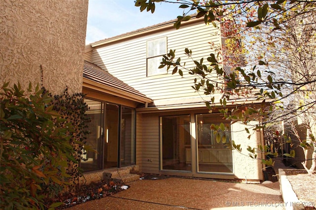 view of exterior entry featuring a patio