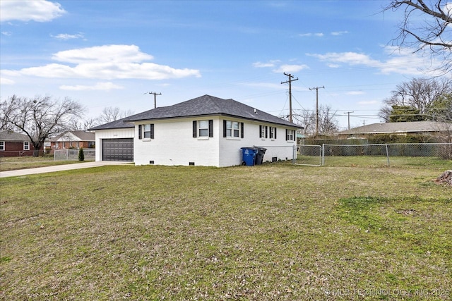 view of home's exterior featuring brick siding, an attached garage, fence, a yard, and driveway