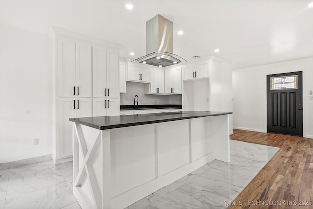 kitchen featuring recessed lighting, marble finish floor, white cabinetry, and island exhaust hood