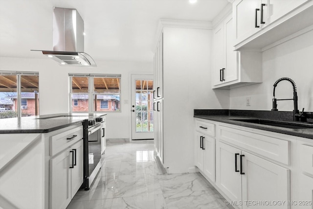 kitchen featuring stainless steel electric stove, white cabinets, island range hood, marble finish floor, and a sink