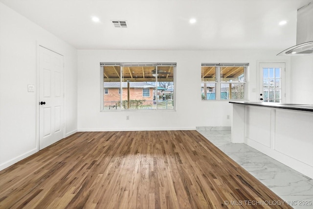 unfurnished living room featuring recessed lighting, baseboards, visible vents, and marble finish floor