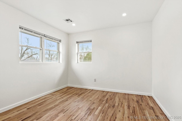 unfurnished room with recessed lighting, baseboards, visible vents, and light wood finished floors