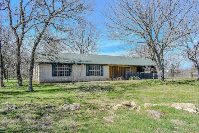 ranch-style house featuring a front yard and brick siding