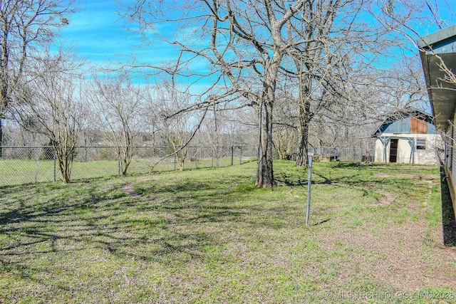 view of yard featuring a barn, an outdoor structure, and fence