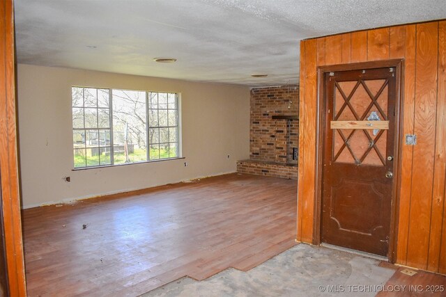 empty room with a textured ceiling and wood finished floors