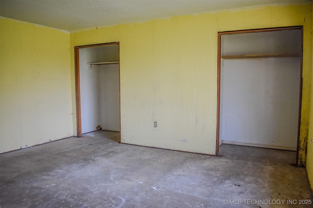 unfurnished bedroom with concrete flooring