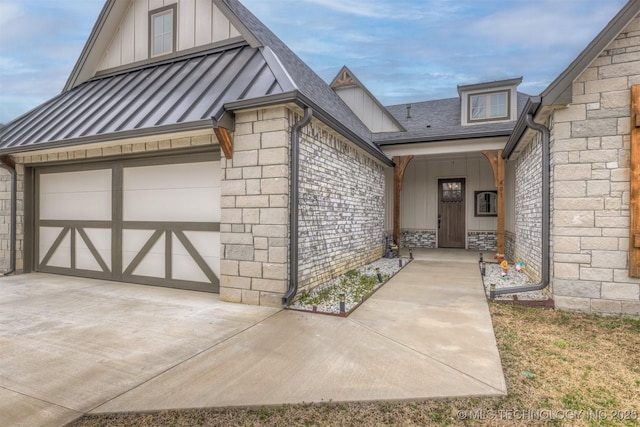 view of exterior entry with a standing seam roof, roof with shingles, board and batten siding, metal roof, and a garage