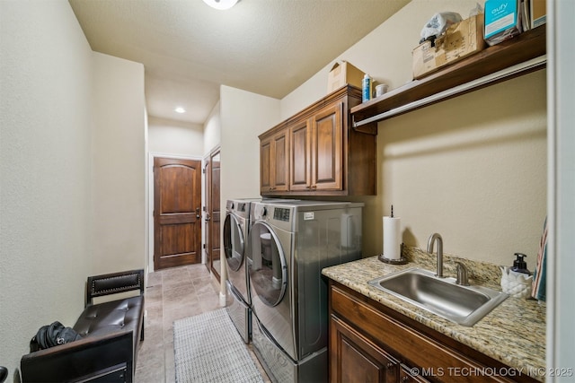 clothes washing area featuring cabinet space, separate washer and dryer, and a sink