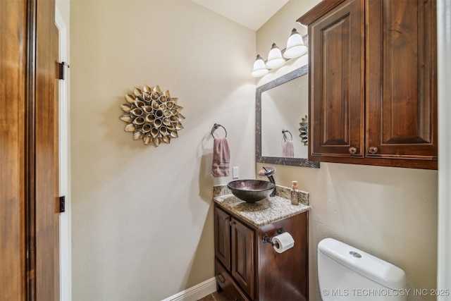 bathroom with vanity, toilet, and baseboards