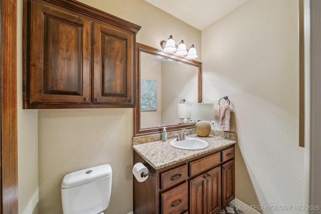 half bathroom with toilet and vanity