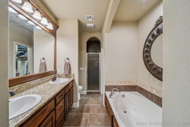 full bathroom featuring a shower stall, a tub with jets, visible vents, and a sink