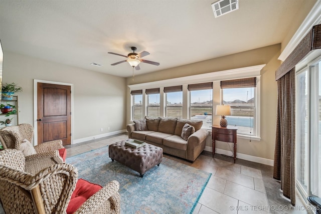 living room featuring light tile patterned floors, visible vents, and baseboards