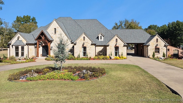 french country style house with stone siding and a front yard