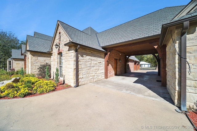 2365 Deer Run, Chouteau, OK 74337 - view of home's exterior featuring a high end roof, stone siding, and concrete driveway