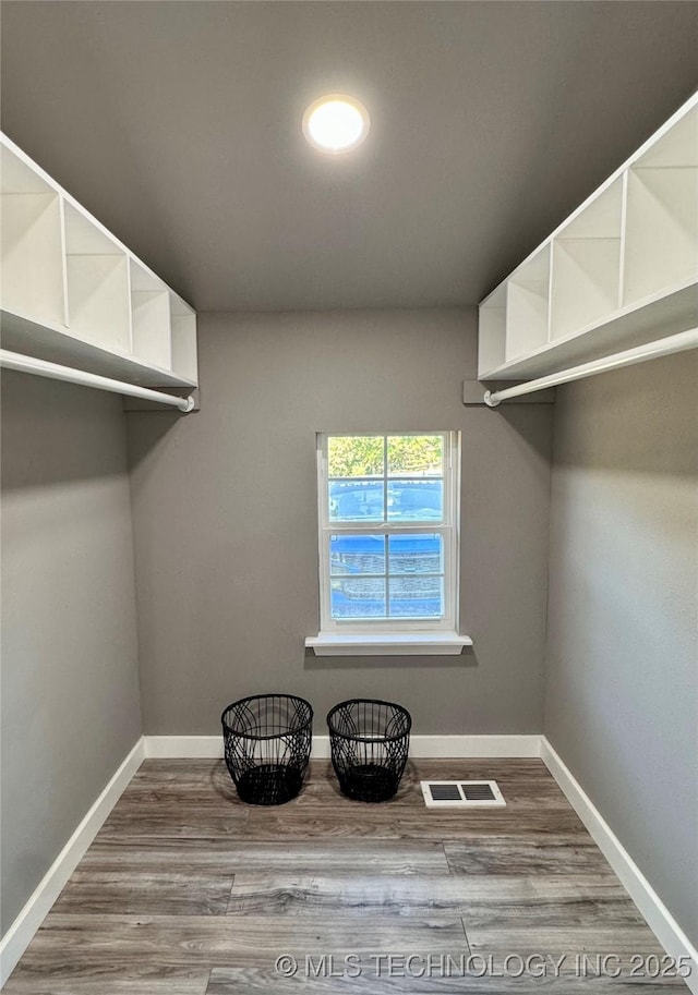 walk in closet with visible vents and wood finished floors