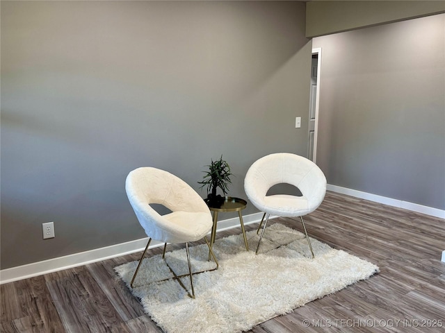 sitting room with baseboards and wood finished floors