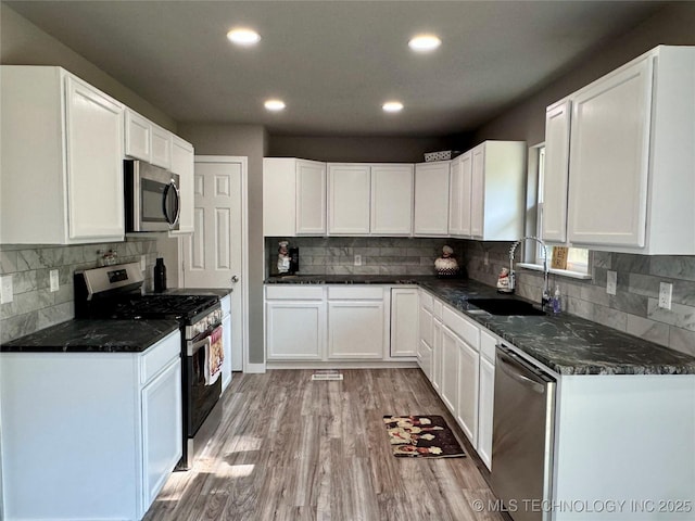 kitchen featuring light wood finished floors, white cabinets, and appliances with stainless steel finishes