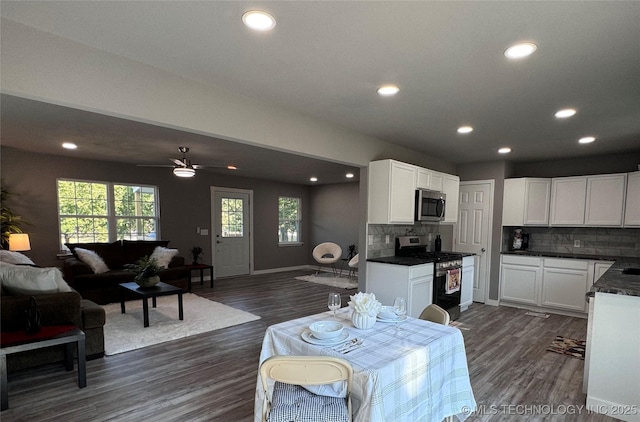 interior space with dark countertops, open floor plan, dark wood-type flooring, and stainless steel appliances