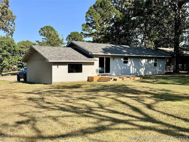 rear view of house featuring a lawn