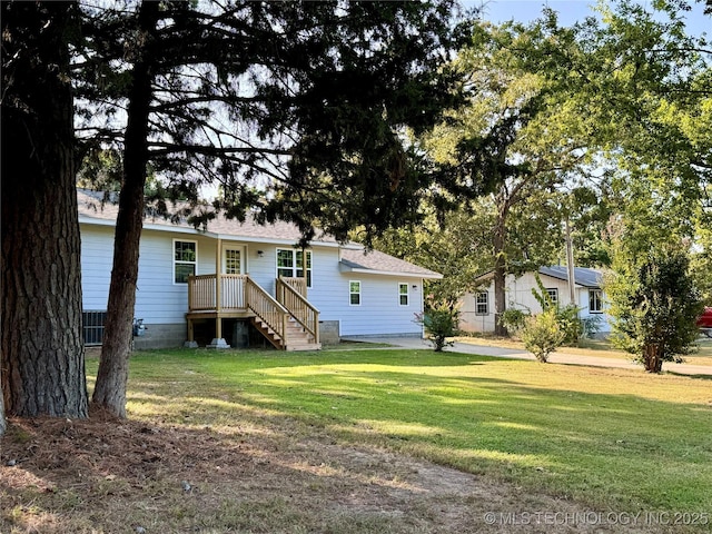 rear view of property featuring a yard and a shingled roof