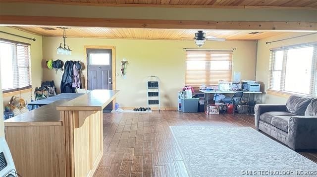 living area featuring beam ceiling, wooden ceiling, and wood finished floors