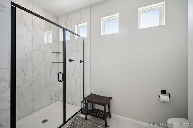 full bathroom featuring a marble finish shower, toilet, and baseboards