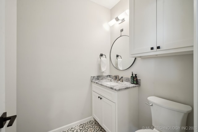 bathroom featuring baseboards, toilet, and vanity