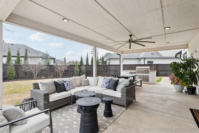 view of patio / terrace featuring an outdoor hangout area, a fenced backyard, area for grilling, an outdoor kitchen, and a ceiling fan