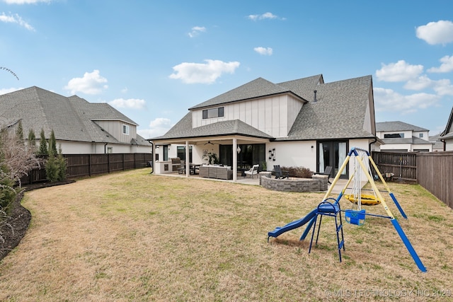 rear view of property with a playground, a lawn, outdoor lounge area, a fenced backyard, and a patio area