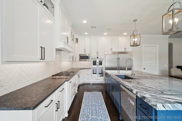 kitchen featuring visible vents, a sink, built in appliances, white cabinetry, and blue cabinets