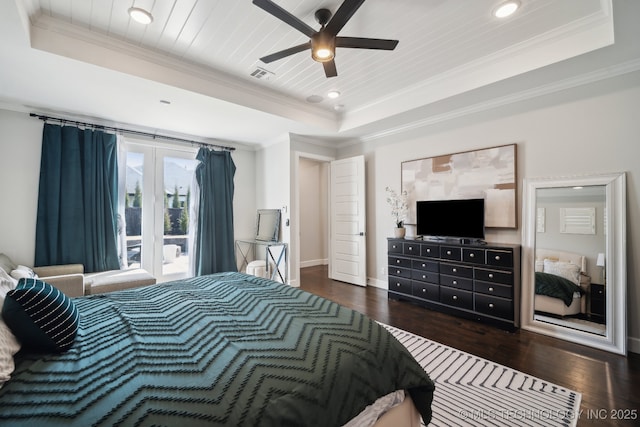 bedroom with visible vents, a raised ceiling, and dark wood-type flooring