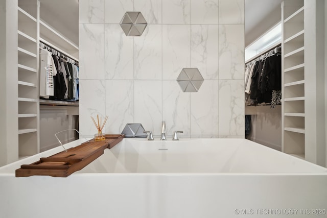 interior space featuring a freestanding bath and a spacious closet