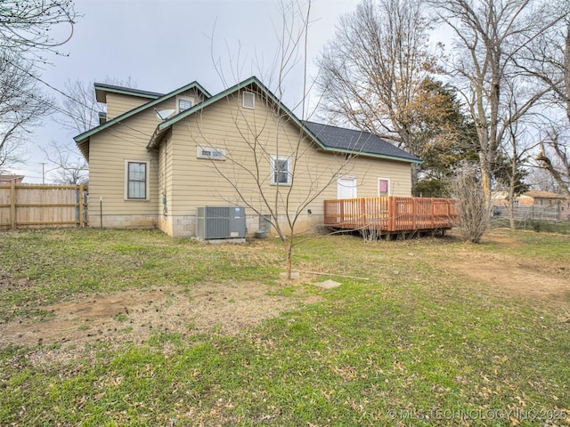 back of house featuring a deck, fence, a lawn, and central AC