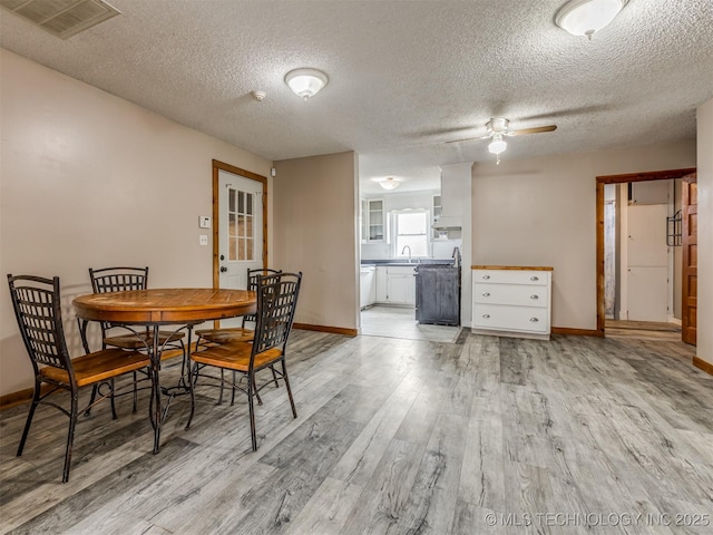 dining space with ceiling fan, baseboards, visible vents, and light wood-type flooring