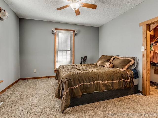 bedroom featuring ceiling fan, a textured ceiling, baseboards, and carpet floors