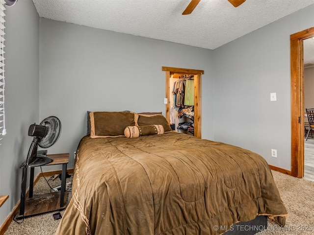 bedroom featuring ceiling fan, a textured ceiling, baseboards, and carpet floors