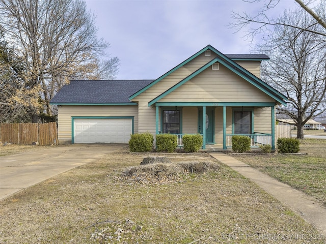 view of front of home with a shingled roof, fence, covered porch, a garage, and driveway