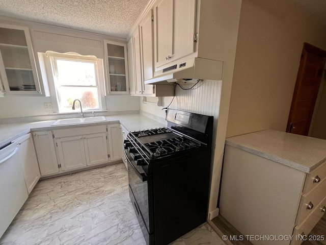 kitchen featuring marble finish floor, under cabinet range hood, a sink, a textured ceiling, and black range with gas cooktop