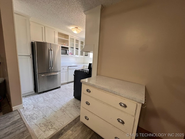 kitchen with open shelves, white dishwasher, freestanding refrigerator, light countertops, and a textured ceiling