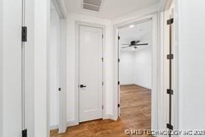 corridor featuring visible vents and wood finished floors